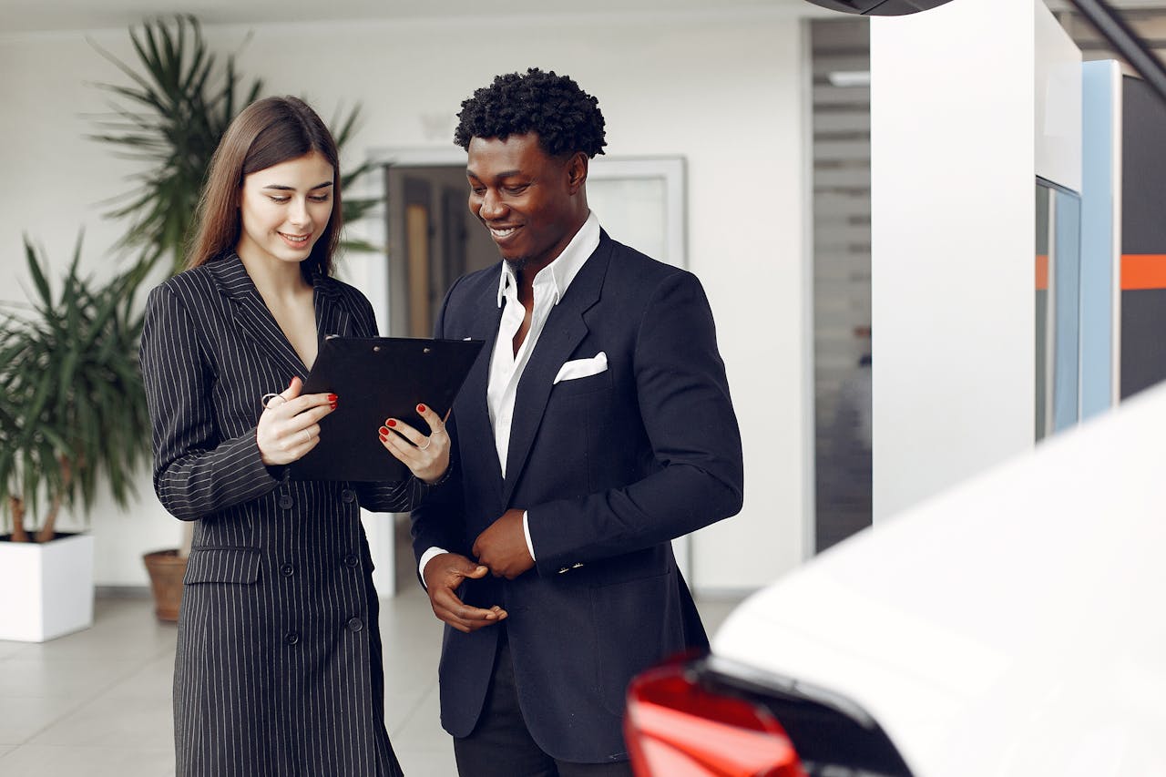 about-02 Two professionals discussing options inside a car dealership.